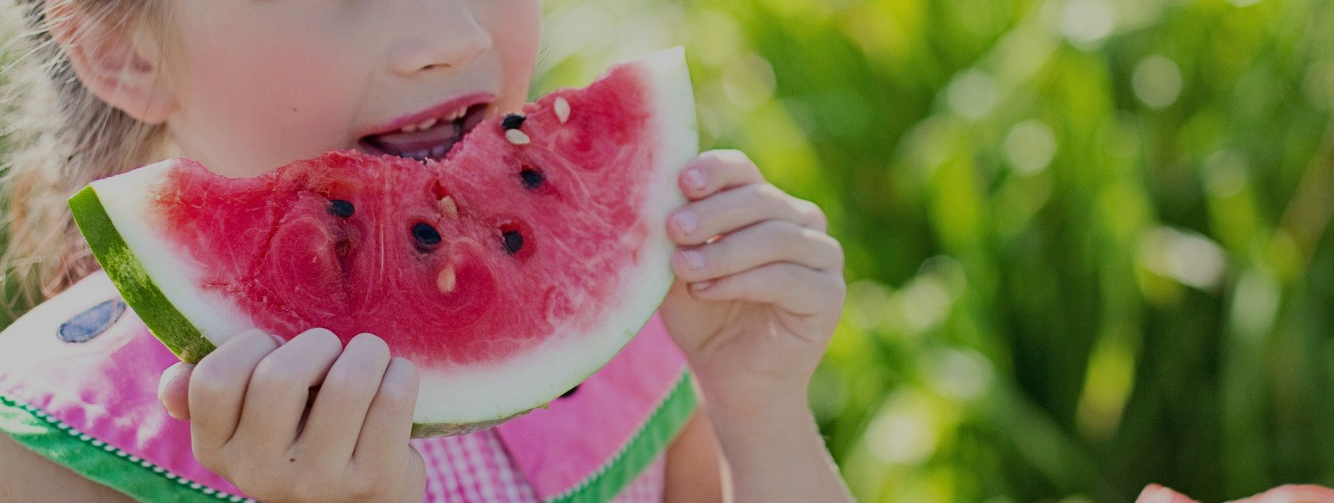 child eating fresh slice of watermelon